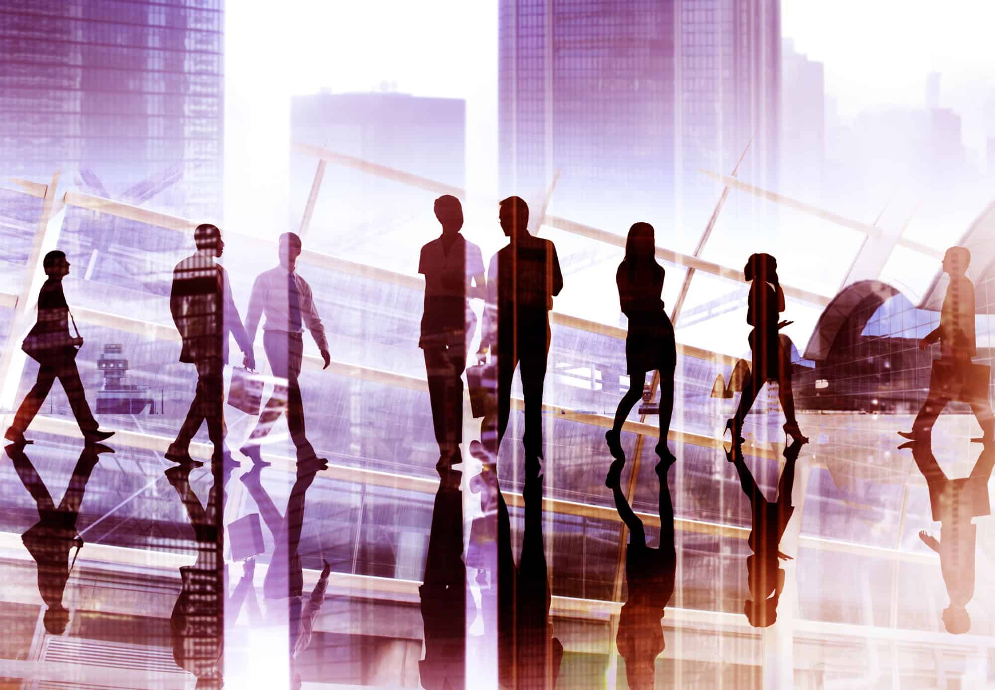 Silhouettes of people walking in an urban setting, reflective surfaces, and a cityscape background with modern architecture evoke the dynamic energy of 2025. This scene captures the evolving landscape where trending C-Suite roles shape the future of innovative urban environments.